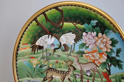 Macro close-up of the Cloisonné plate showing intricate gold wire filigree and vibrant enamel details of the white cranes and floral patterns.