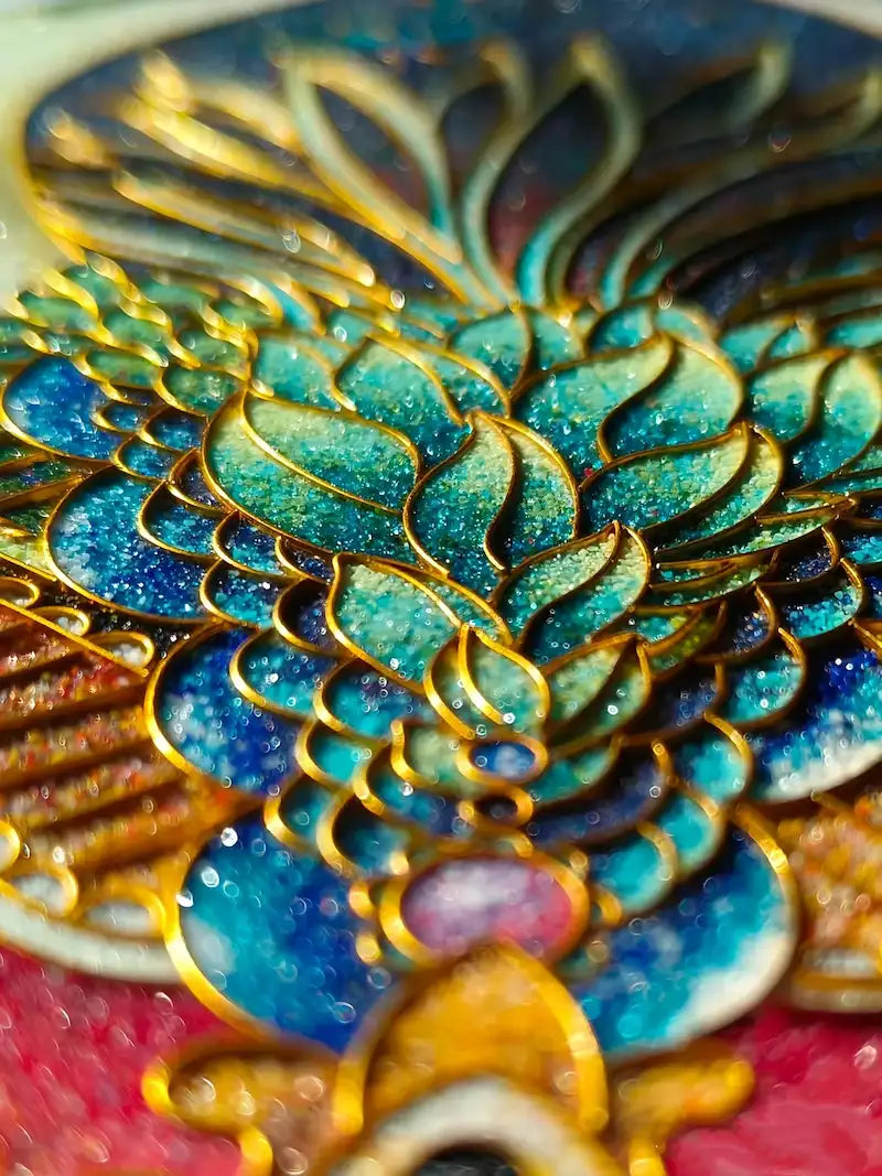 Macro close-up of handcrafted cloisonné enamel art, showcasing intricate gold wire filigree and vibrant blue-green gradients with a rich granular texture.