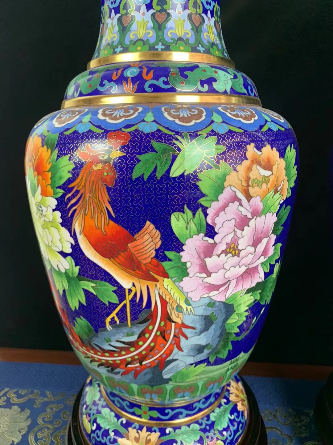 Detailed close-up of the Cloisonné vase body featuring a vibrant phoenix and pink peony, showcasing intricate gold wire filigree and hand-painted mineral enamel.