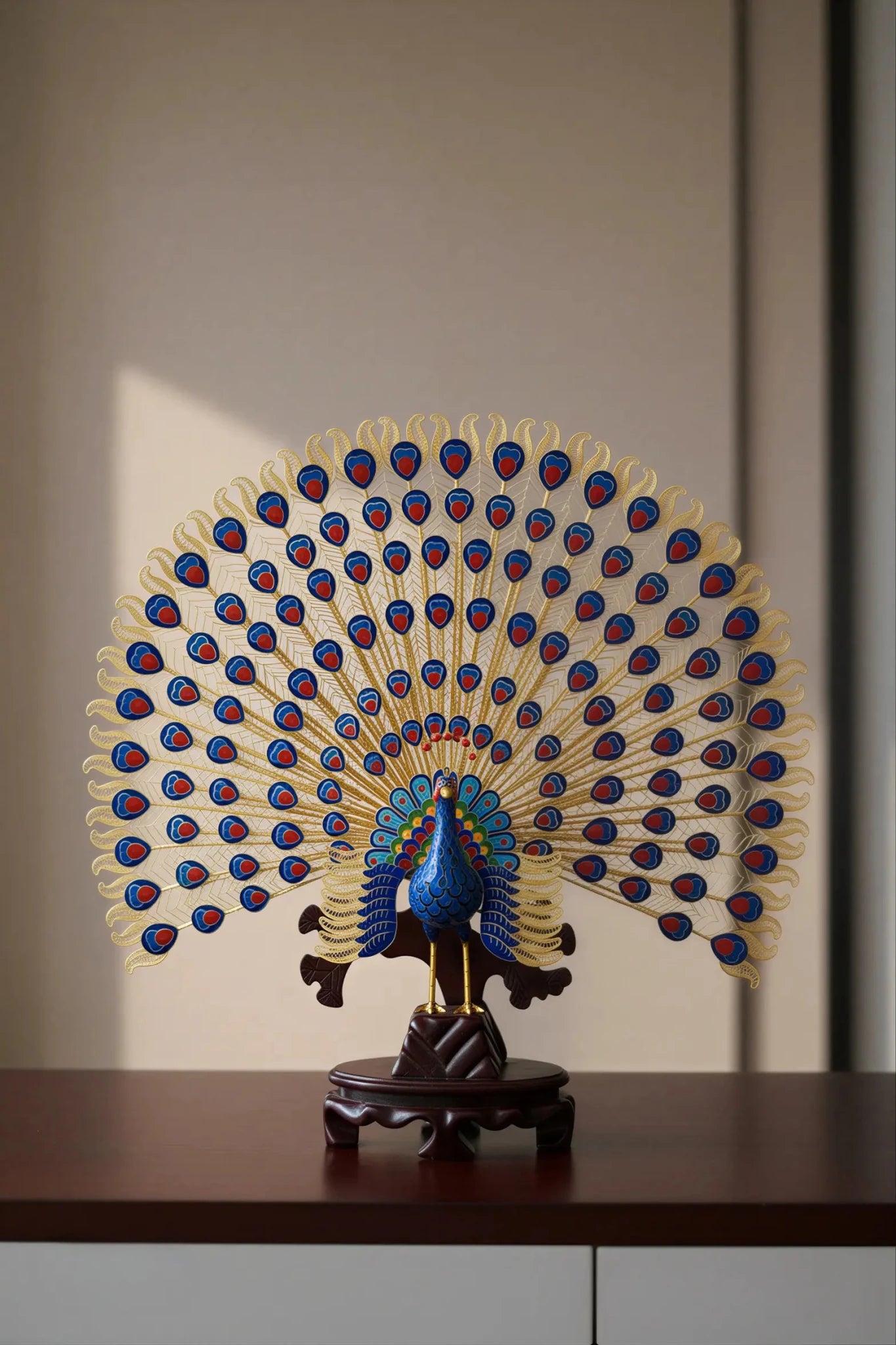 Exquisite handcrafted cloisonné enamel peacock statue with vibrant blue and green feathers, featuring intricate gold filigree work and a decorative base.